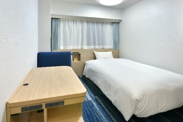 広い天板のワイドデスクを設置したシングルルーム